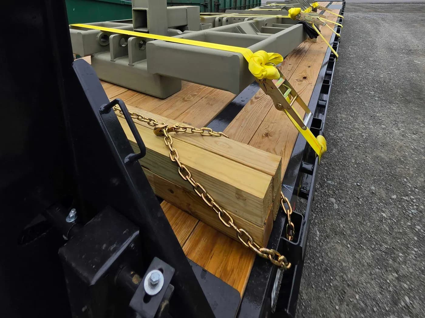 Ratchet straps and transport chains securing machinery to a trailer deck